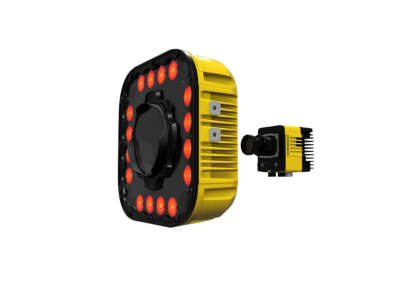 A yellow industrial vision sensor with a black circular front and red indicator lights, shown with a smaller matching camera module on a black background.